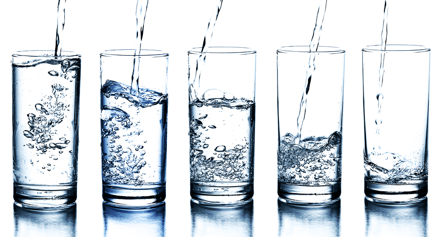 five water glasses being filled in descending order